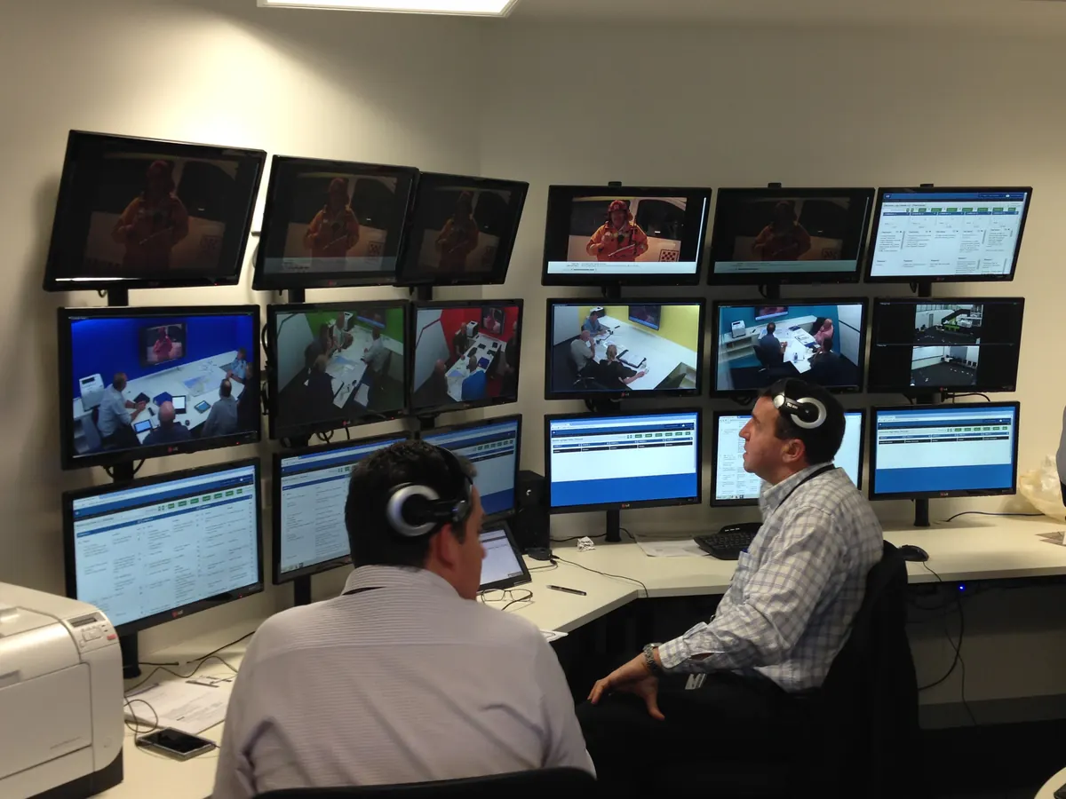 Two Hydra operators wearing headsets and monitoring exercise discussions at Victoria Police