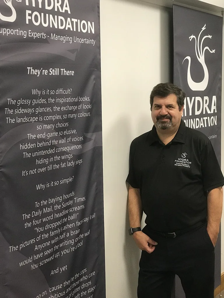 Professor Jonathan Crego beside Hydra Foundation banners